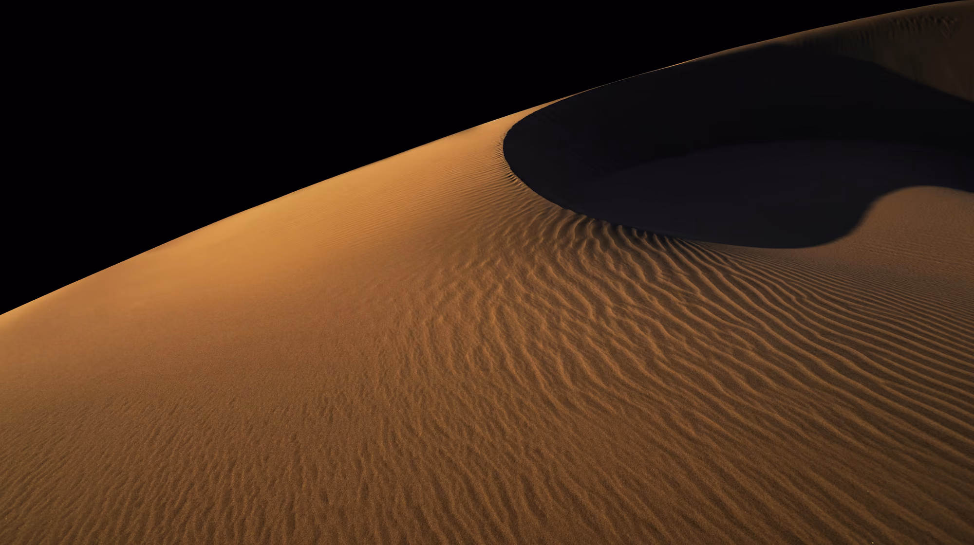 Desert sand ripples beneath a starry night sky